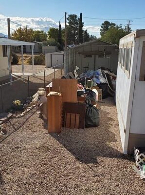 A cluttered outdoor area with scattered furniture and various items.